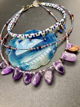Load image into Gallery viewer, The Genuine Amethyst Natural Gemstone Adjustable Chocker Style Glass Beaded Necklace features vibrant violet and white tones. Its unique draped beading creates a beautiful style with a series of short strands of glass beads for movement and a longer strand with a multitude of amethyst nugget beads. The collar necklace hangs gracefully along the neck and chest, making it a dream come true for violet lovers.  Measurements:  Necklace is 15” in length adjustable to 18" in length