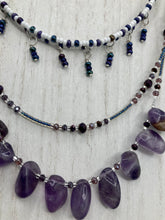 Load image into Gallery viewer, The Genuine Amethyst Natural Gemstone Adjustable Chocker Style Glass Beaded Necklace features vibrant violet and white tones. Its unique draped beading creates a beautiful style with a series of short strands of glass beads for movement and a longer strand with a multitude of amethyst nugget beads. The collar necklace hangs gracefully along the neck and chest, making it a dream come true for violet lovers.  Measurements:  Necklace is 15” in length adjustable to 18" in length