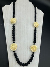Load image into Gallery viewer, This Cocktail Chic Long Beaded Necklace is a unique piece that can be styled in different ways. Crafted with black flat matte glass beads for a luxurious look, the necklace is complemented by small and large white rose beads for contrast. The intricate petal details give the piece an extra special touch. This set is a simple and elegant pieces, very versatile looks and comes with a pair of matching earrings. Perfect cocktail chic attire, fancy wedding necklace, a minimalist look.