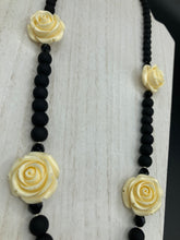 Load image into Gallery viewer, This Cocktail Chic Long Beaded Necklace is a unique piece that can be styled in different ways. Crafted with black flat matte glass beads for a luxurious look, the necklace is complemented by small and large white rose beads for contrast. The intricate petal details give the piece an extra special touch. This set is a simple and elegant pieces, very versatile looks and comes with a pair of matching earrings. Perfect cocktail chic attire, fancy wedding necklace, a minimalist look.