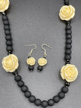 Load image into Gallery viewer, This Cocktail Chic Long Beaded Necklace is a unique piece that can be styled in different ways. Crafted with black flat matte glass beads for a luxurious look, the necklace is complemented by small and large white rose beads for contrast. The intricate petal details give the piece an extra special touch. This set is a simple and elegant pieces, very versatile looks and comes with a pair of matching earrings. Perfect cocktail chic attire, fancy wedding necklace, a minimalist look.