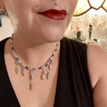 Load image into Gallery viewer, Silver And Blue Wise Owl Charm Choker Style Glass Beaded Necklace. Whimsical and elegant necklace has two different styles of tiny cute owls with silver plated feathers. Some say wearing an owl pendant around your neck is just want you need for a better connection to your intuition. Owls symbolize wisdom, the wisdom that comes to prevent hasting rushing or being impulsive. Necklace comes with matching earrings, necklace is 16” adjustable up to 18" in length - hanging owls and feather pendant are 2” Height