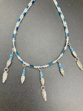 Load image into Gallery viewer, Silver And Blue Wise Owl Charm Choker Style Glass Beaded Necklace. Whimsical and elegant necklace has two different styles of tiny cute owls with silver plated feathers. Some say wearing an owl pendant around your neck is just want you need for a better connection to your intuition. Owls symbolize wisdom, the wisdom that comes to prevent hasting rushing or being impulsive. Necklace comes with matching earrings, necklace is 16” adjustable up to 18" in length - hanging owls and feather pendant are 2” Height