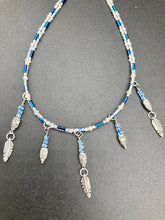 Load image into Gallery viewer, Silver And Blue Wise Owl Charm Choker Style Glass Beaded Necklace. Whimsical and elegant necklace has two different styles of tiny cute owls with silver plated feathers. Some say wearing an owl pendant around your neck is just want you need for a better connection to your intuition. Owls symbolize wisdom, the wisdom that comes to prevent hasting rushing or being impulsive. Necklace comes with matching earrings, necklace is 16” adjustable up to 18" in length - hanging owls and feather pendant are 2” Height