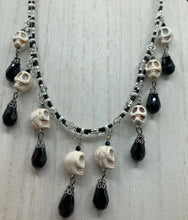 Load image into Gallery viewer, Black And White Vampire Goth Skulls Choker Style Necklace, Skully Witchy Vibe, Goth Dark Souls Jewelry, Day Of The Dead, Dia De Los Muertos, Howlite Skull Beads Black And Silver Glass BeadsThis statement necklace radiates a dark, shimmering aesthetic with two strands of glass beads connected through double-hole silver and black beads to create a collar shape. These dangling skulls beads are acompanied by black teardrop glass beads enable the piece to flow elegantly and express a bold, fierce look.