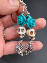 Load image into Gallery viewer, Frida Kahlo Inspired Earrings, Howlite Skull And Turquoise Quartize Floral Beads. This beautifully and elegant set of earrings captures Frida Kahlo's signature floral crown on her head. Dangling silver plated intricate leaf at the bottom to give these earrings some movement. These are a beautiful piece of jewelry to wear for inspiration or a great Dia De Los Muertos jewelry piece. Chingona, Cabrona, Latina Chicana, Goth, Vampire Goth, Dark Witchy Style. 2 ” in length