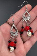 Load image into Gallery viewer, Frida Kahlo Inspired Earrings, Tiny Howlite Skull Beads With Red Quartize Rose Beads. Elegant set of earrings captures Frida Kahlo's signature floral crown on her head. Red and black shimmery glass beads to give a little pop of color and incorporated some movement. These are a beautiful piece of jewelry to wear for inspiration or a great Dia De Los Muertos jewelry piece. You can dress these up or down, it will definitely give your outfit a unique look. 2 ” in length