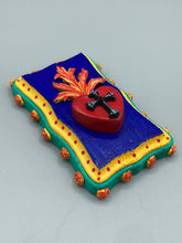 Load image into Gallery viewer, This Sacred Heart Wall Art Decor is the perfect way to enhance your home with an artistic flair. This Sacred Heart Wall Art Decor is crafted with a stunning red heart detailed with a black-silver cross and a vibrant fire embellishment at its center. Adding to its unique traditional Mexican aesthetic, the wood frame is decorated with marigold flowers, creating a beautiful and eye-catching artwork.