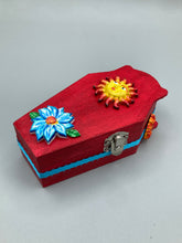 Load image into Gallery viewer, This coffin-shaped box features a bright red exterior, with a bold yellow, orange and red sun adorning the center. Complemented with a shimmery turquoise-blue ribbon and flower, the inside is painted in a dark royal blue hue with turquoise crescent moon detailing and traditional Mexican-themed fabric. Coffin Dimensions: Length: 4 1/2 Inches; Width: 2 1/2 inches; Height: 1 5/8 Inches
