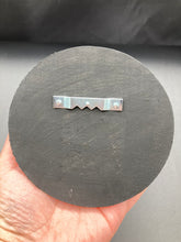 Load image into Gallery viewer, This handcrafted Dia De Los Muertos Calavera wall art decor is a unique way to bring life to your home and celebrates Mexican culture. Made with polymere clay and painted on a wooden frame, the beautiful blue skull is finished with wings and fleur de lis embellishments for a sophisticated look. Perfect for any room! Measurements: D 4"