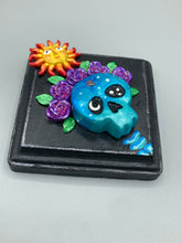 Load image into Gallery viewer, Showcasing a dark theme Frida Kahlo inspired calavera with a dark wood frame, this Day of the Dead wall decor piece is perfect for adding a traditional Mexican folk art touch to any home. Featuring an intricately detailed clay calavera in the style of Frida Kahlo, this Day of the Dead wall art decor is sure to be the centerpiece of any home décor. The calavera is wearing Frida's iconic crown of flowers, ensuring it will bring both a unique and inspiring look to any wall.