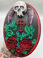 Load image into Gallery viewer, This Memento Mori Wall Art Decor is a one-of-a-kind art piece, skillfully crafted with a black polymer clay skull and wings on a dark red wood frame, decoratively woven with dark red roses and vines. It's perfect for adding an eye-catching touch to any wall and makes a unique, bold gift.  Measurements: H 7" x W 5” x D 1 1/2"