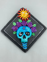Load image into Gallery viewer, Showcasing a dark theme Frida Kahlo inspired calavera with a dark wood frame, this Day of the Dead wall decor piece is perfect for adding a traditional Mexican folk art touch to any home. Featuring an intricately detailed clay calavera in the style of Frida Kahlo, this Day of the Dead wall art decor is sure to be the centerpiece of any home décor. The calavera is wearing Frida's iconic crown of flowers, ensuring it will bring both a unique and inspiring look to any wall.