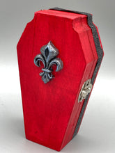 Load image into Gallery viewer, Super vibrant red coffin box has an eye-catching black and gray embellishment in the center, accompanied by a glittery black ribbon around the coffin. Inside, the interior is all black with a floral detailed black-silver cross.
