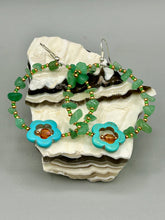 Load image into Gallery viewer, This pair of earrings features a turquoise magnesite floral bead with a vibrant orange glass bead and natural green aventurine stone chips juxtaposed against gold and blue glass beads.  Measurements: 2&quot; length 
