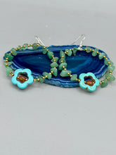Load image into Gallery viewer, This pair of earrings features a turquoise magnesite floral bead with a vibrant orange glass bead and natural green aventurine stone chips juxtaposed against gold and blue glass beads.  Measurements: 2&quot; length 
