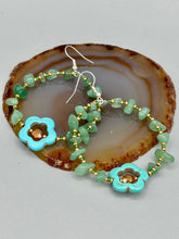 Load image into Gallery viewer, This pair of earrings features a turquoise magnesite floral bead with a vibrant orange glass bead and natural green aventurine stone chips juxtaposed against gold and blue glass beads.  Measurements: 2&quot; length 
