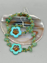 Load image into Gallery viewer, This pair of earrings features a turquoise magnesite floral bead with a vibrant orange glass bead and natural green aventurine stone chips juxtaposed against gold and blue glass beads.  Measurements: 2&quot; length 
