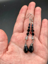 Load image into Gallery viewer, These shimmering black and silver glass beaded earrings feature a large black teardrop glass bead for added movement. This sophisticated and versatile accessory can be worn for an elegant evening look, brunch ensemble, wedding necklace, or minimalist style.  Measurements: 2 1/2” in length

