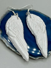 Load image into Gallery viewer, Shimmery white polymer clay earrings in the shape of angel wings are perfect for a subtle yet elegant look.
