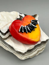 Load image into Gallery viewer, This hand-crafted art magnet is featuring a black bat with an ombre background of yellow, orange and bright red. This art clay magnet is the ideal home decor for Halloween enthusiasts. Perfect for adorning a witchy altar, goth, or spooky Halloween home decor.  Halloween magnet art to add to your fridge, locker, cubicle or toolbox. This hand-crafted heart-shaped magnet features a black bat figurine with ombre colors of yellow, orange and bright red.
