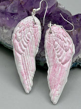 Load image into Gallery viewer, Light pastel pink polymer clay earrings in the shape of angel wings are perfect for a subtle yet elegant look. These earrings are designed to face forward when worn for a more flattering silhouette.
