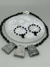 Load image into Gallery viewer, This sophisticated pair of earrings features a black glass fish bead, complemented by small iridescent and dark gray color glass beads, with eye and fin details.  Measurements: 2” in length    
