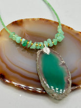 Load image into Gallery viewer, This Dark Green Agate Geode Sliced Stone Chip Necklace is a statement piece for your jewelry collection. It features a bold dark green agate geode pendant surrounded by a green aventurine, gold tone and green glass beaded necklace. The silver leaf bail completes this chic, Boho-inspired necklace.  Measurements:   Necklace is 19” in length - pendant is 2 1/4” Height
