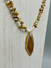 Load image into Gallery viewer, This Light Brown Banded Agate Geode Sliced Stone Chip Necklace is a luxurious addition to any jewelry collection. It features natural, light brown agate banded geode in a luxurious earth-tone. Suspended on a unique strand of natural bamboo chips and gold and clear beaded necklace. The combination of neutral colors and nature inspired design makes them the perfect accessory for any outfit.   Measurements:    Necklace is 18” in length - pendant is 2” Height
