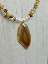 Load image into Gallery viewer, This Light Brown Banded Agate Geode Sliced Stone Chip Necklace is a luxurious addition to any jewelry collection. It features natural, light brown agate banded geode in a luxurious earth-tone. Suspended on a unique strand of natural bamboo chips and gold and clear beaded necklace. The combination of neutral colors and nature inspired design makes them the perfect accessory for any outfit.   Measurements:    Necklace is 18” in length - pendant is 2” Height

