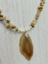 Load image into Gallery viewer, This Light Brown Banded Agate Geode Sliced Stone Chip Necklace is a luxurious addition to any jewelry collection. It features natural, light brown agate banded geode in a luxurious earth-tone. Suspended on a unique strand of natural bamboo chips and gold and clear beaded necklace. The combination of neutral colors and nature inspired design makes them the perfect accessory for any outfit.   Measurements:    Necklace is 18” in length - pendant is 2” Height
