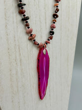Load image into Gallery viewer, Unlock your inner goddess with this stunning Large Fuchsia Agate Geode Sliced Stone Chip Necklace. Featuring a vibrant fuchsia agate geode pendant surrounded by Rhodonite stone chips and gold and black glass beading, the silver leaf bail completes this chic and boho-inspired look. Make a bold statement with this bohemian-style gemstone necklace.   Measurements:    Necklace is 17 3/4” in length - pendant is 3” Height
