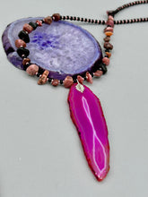 Load image into Gallery viewer, Unlock your inner goddess with this stunning Large Fuchsia Agate Geode Sliced Stone Chip Necklace. Featuring a vibrant fuchsia agate geode pendant surrounded by Rhodonite stone chips and gold and black glass beading, the silver leaf bail completes this chic and boho-inspired look. Make a bold statement with this bohemian-style gemstone necklace.   Measurements:    Necklace is 17 3/4” in length - pendant is 3” Height
