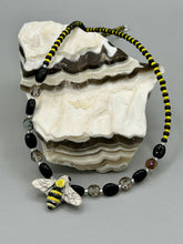 Load image into Gallery viewer, This beautiful Bee Pendant With Black and Yellow Beaded Necklace is the perfect accessory for any summer outfit. The vibrant colors will make a bold statement, while the black and gold blend adds a subtle elegance. Its perfect for any nature lover, hippie, or witchy style.  Measurements:  Necklace is 18”
