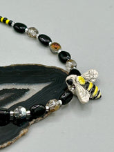 Load image into Gallery viewer, This beautiful Bee Pendant With Black and Yellow Beaded Necklace is the perfect accessory for any summer outfit. The vibrant colors will make a bold statement, while the black and gold blend adds a subtle elegance. Its perfect for any nature lover, hippie, or witchy style.  Measurements:  Necklace is 18”
