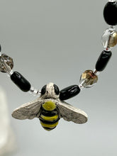 Load image into Gallery viewer, This beautiful Bee Pendant With Black and Yellow Beaded Necklace is the perfect accessory for any summer outfit. The vibrant colors will make a bold statement, while the black and gold blend adds a subtle elegance. Its perfect for any nature lover, hippie, or witchy style.  Measurements:  Necklace is 18”
