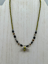 Load image into Gallery viewer, This beautiful Bee Pendant With Black and Yellow Beaded Necklace is the perfect accessory for any summer outfit. The vibrant colors will make a bold statement, while the black and gold blend adds a subtle elegance. Its perfect for any nature lover, hippie, or witchy style.  Measurements:  Necklace is 18”
