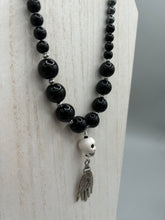 Load image into Gallery viewer, This elegant Peruvian ceramic skull beaded necklace is the perfect accessory for your unique look. With a large skull bead and a lucky hand charm, it exudes a dark, alluring vibe. Complemented with black glass and hematite stone beads, it will make a bold statement. Measurements:  Necklace: 19” in length - skulls with lucky hand charm is 2 3/4” Height
