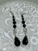 Load image into Gallery viewer, These shimmering black and silver glass beaded earrings feature a large black teardrop glass bead for added movement. This sophisticated and versatile accessory can be worn for an elegant evening look, brunch ensemble, wedding necklace, or minimalist style.  Measurements: 2 1/2” in length
