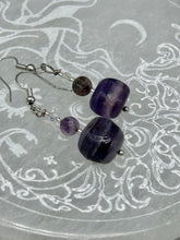 Load image into Gallery viewer, This luxurious set of earrings feature large square-shaped rainbow fluorite beads contrasted against round amethyst beads, presenting an elegant neutral yet cool-toned look. With its unique and versatile style, these earrings make a perfect addition to any wardrobe.  Measurements: 1 3/8” in length
