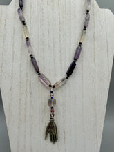 Load image into Gallery viewer, This nature-inspired accessory features an array of unique hues, including rectangular-shaped rainbow fluorite stone beads, round amethyst beads and dark purple glass beads. The secure hook-eye clasp makes it perfect for day to night wear, allowing you to add a touch of summer to your wardrobe. The necklace is further complemented by a large square-shaped rainbow fluorite bead and a lucky hand charm.  Measurements:  Necklace: 18&quot;, Lucky hand pendant 3&quot;
