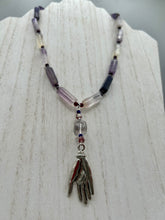 Load image into Gallery viewer, This nature-inspired accessory features an array of unique hues, including rectangular-shaped rainbow fluorite stone beads, round amethyst beads and dark purple glass beads. The secure hook-eye clasp makes it perfect for day to night wear, allowing you to add a touch of summer to your wardrobe. The necklace is further complemented by a large square-shaped rainbow fluorite bead and a lucky hand charm.  Measurements:  Necklace: 18&quot;, Lucky hand pendant 3&quot;
