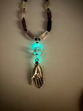 Load image into Gallery viewer, This nature-inspired accessory features an array of unique hues, including rectangular-shaped rainbow fluorite stone beads, round amethyst beads and dark purple glass beads. The secure hook-eye clasp makes it perfect for day to night wear, allowing you to add a touch of summer to your wardrobe. The necklace is further complemented by a large square-shaped rainbow fluorite bead, a lucky hand charm and two glow in the dark beads!  Measurements:  Necklace: 18&quot;, Lucky hand pendant 3&quot;
