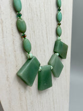 Load image into Gallery viewer, This expertly crafted necklace features a large trapezoid-shaped green aventurine stone, mint green melon beads with gold shimmer, and teal glass beads with an amber tone. Intricately arranged together, this piece offers genuine stones and an elegant bohemian style.  Measurements:  Necklace is 19&quot;
