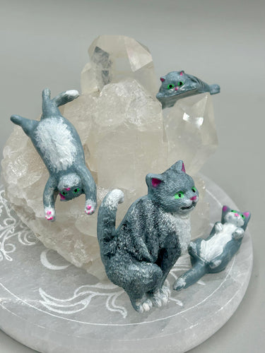 Cat lovers dream, this hand-crafted gray tabby cat magnet art is the purrfect decoration on refrigerators, lockers, cubicles or toolboxes. The set includes three mini cat figurines, featuring emerald green eyes.   Measurements:   H 2” x W 1/2” x D 3/8” - Cat Magnet  H 2” x W 3/8” x D 3/8” -   Cat Figurines