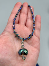 Load image into Gallery viewer, Make a bold statement with this shimmery aqua blue and blue tones glass beaded necklace. The round faceted shaped pendant compliments the cool tones of the necklace, perfect for adding a rich pop of color to any Spring outfit. The draped design gives this piece an elegant, bohemian look.  Measurements:    Necklace is 18” in length, pendant is 1 1/2”
