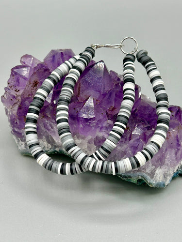 Two strand clay heishi beaded bracelet mixed with black, gray, and white. Crafted with metal wire and fastened with hook-eye clasp.

Measurements: 8 1/4