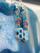 Load image into Gallery viewer, This bold and vibrant piece of jewelry features blue, purple, and gold glass beads of different sizes and shapes that are artfully combined to create a unique texture. An essential addition to any jewelry collection. Measurements: 1 ” in length
