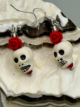 Load image into Gallery viewer, Peruvian off white ceramic skull beads come with quartzite red rose beads. These stylish skull earrings are perfect for adding a unique flair to any outfit. Whether you&#39;re looking for a Dia De Los Muertos accessory or simply looking to draw inspiration, these goth pieces perfectly capture the vampire goth, witchy, dark, Chingona Cabrona, Latina Chicana styles.  Measurements: 1” in length
