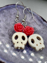 Load image into Gallery viewer, These stylish skull earrings are perfect for adding a unique flair to any outfit. Whether you&#39;re looking for a Dia De Los Muertos accessory or simply looking to draw inspiration, these goth pieces perfectly capture the vampire goth, witchy, dark, Chingona Cabrona, Latina Chicana styles. Crafted with Howlite stone skull beads and pink coral quartzize floral beaded earrings, this jewelry set is a unique stunning statement piece.  Measurements: 1 1/4 ” in length
